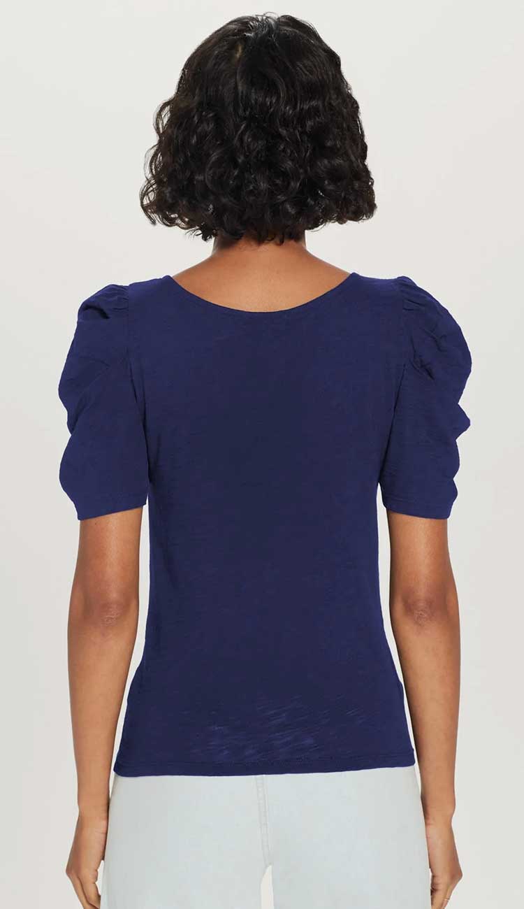 the dutchess t-shirt a model wearing a navy t-shirt with puffy back view on a white background.