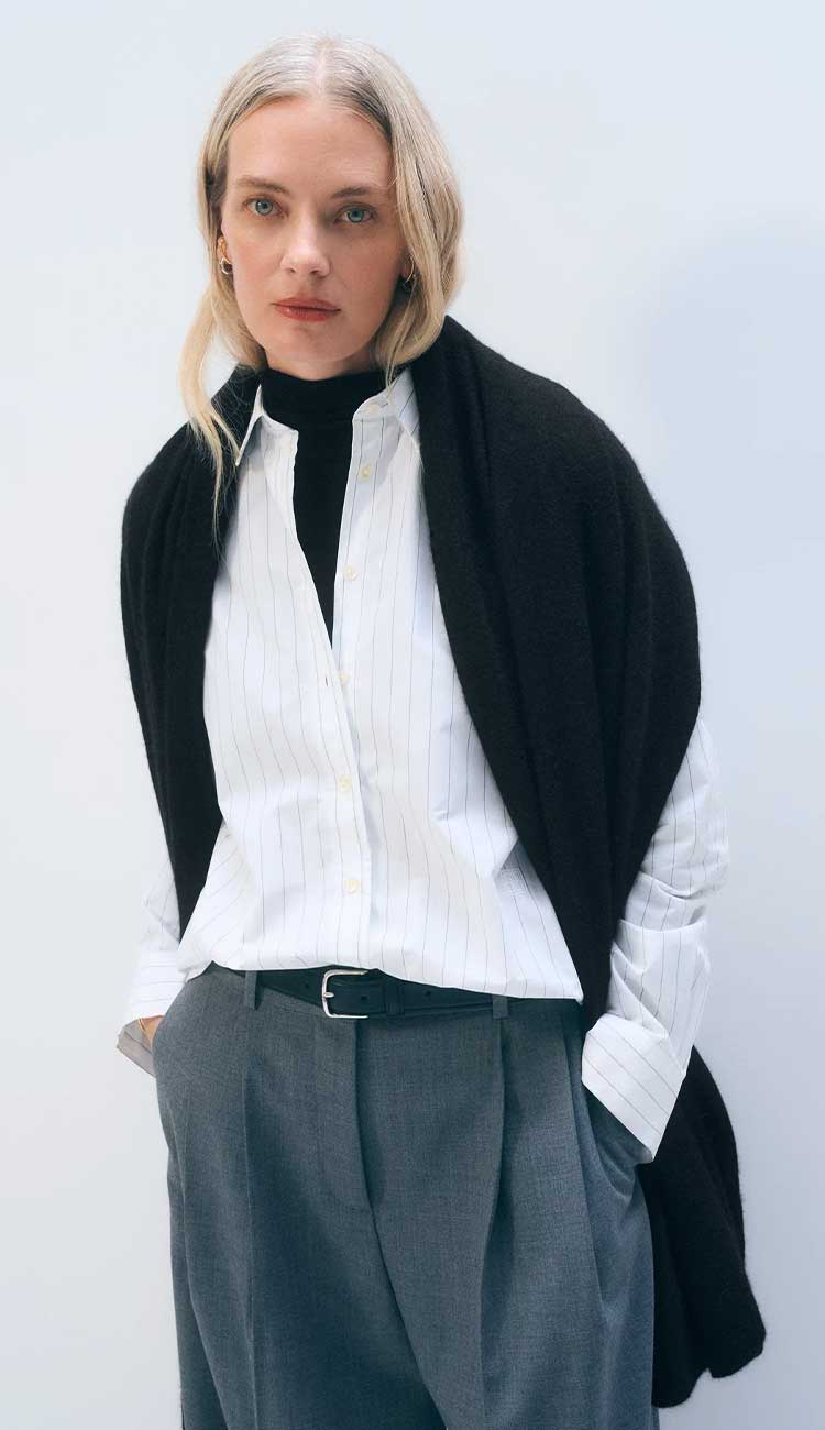 White + Warren cashmere travel wrap in Black, a lightweight rectangular 100% cashmere wrap styled as a scarf.