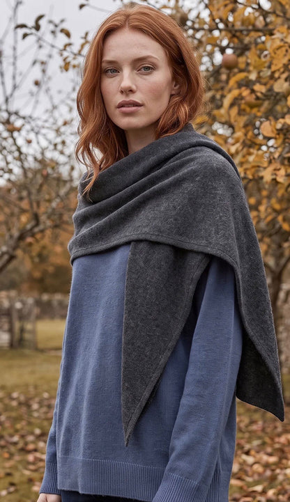 woman wearing a white and warren cashmere triangle scarf wrap in dark slate heather grey with a blue sweater.
