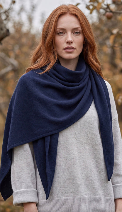 woman wearing a white and warren cashmere triangle scarf wrap with a grey sweater.
