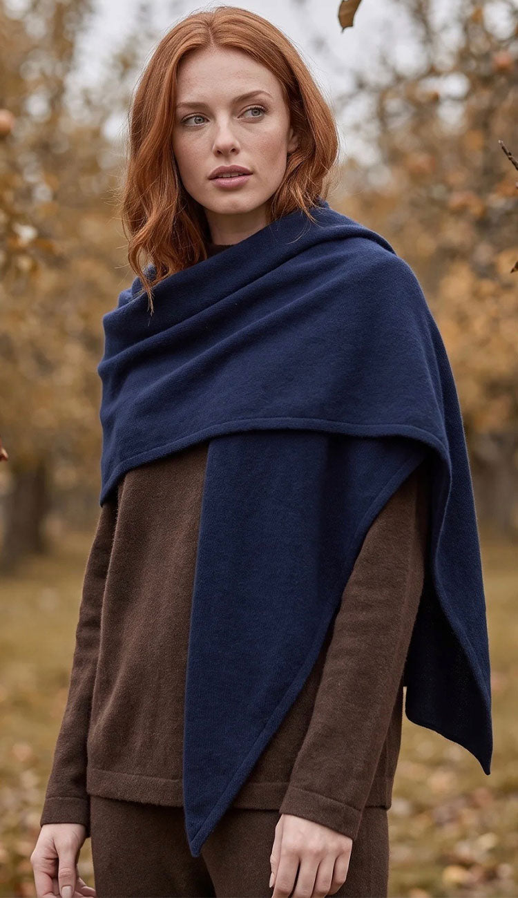 woman wearing a white and warren cashmere triangle scarf wrap with a brown sweater.