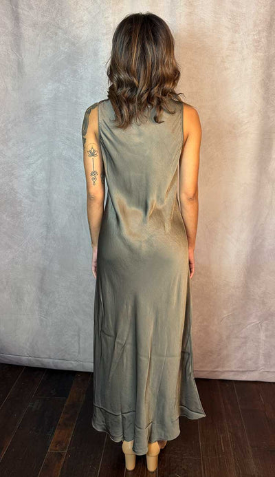 Person wearing a sleeveless mocha dress against a neutral background
