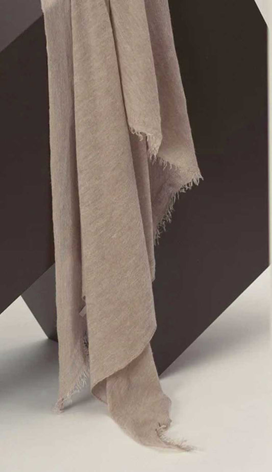 Beige scarf draped over a dark surface on a light background