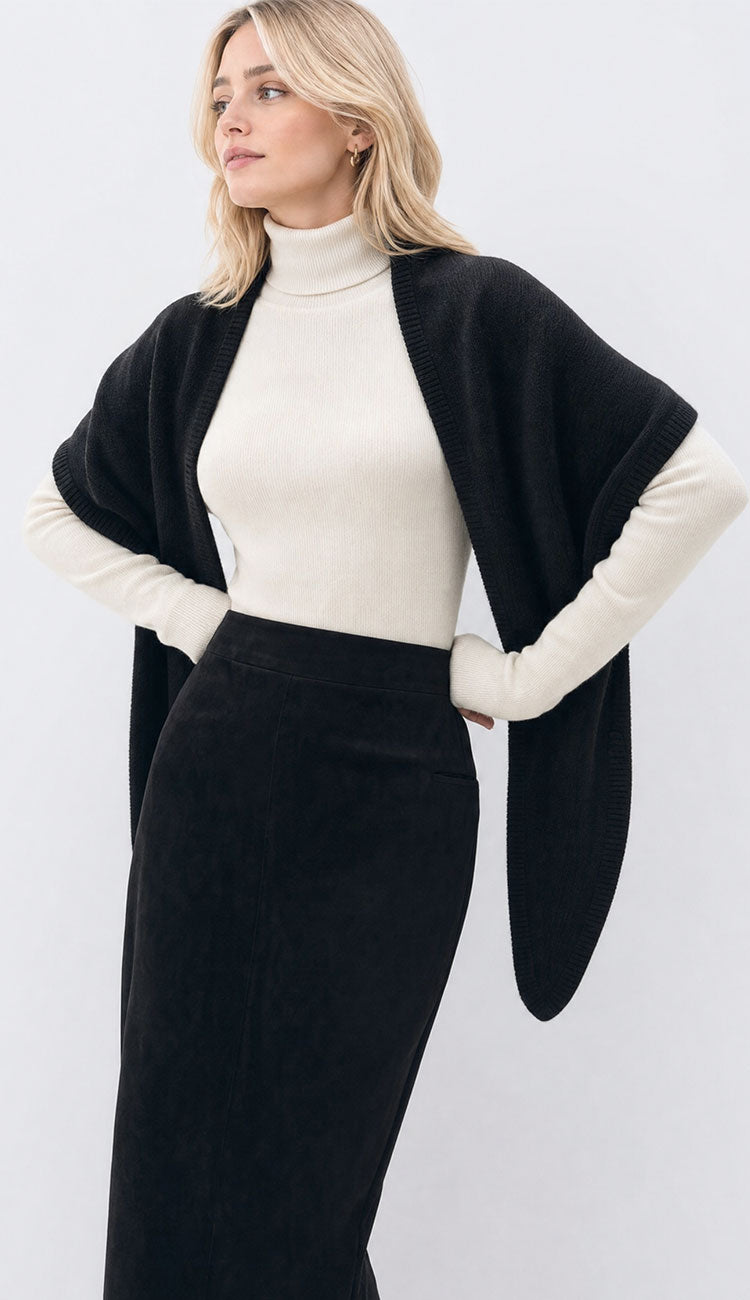Woman wearing ivory turtleneck with a triangle wrap in black with a long black skirt on a white background