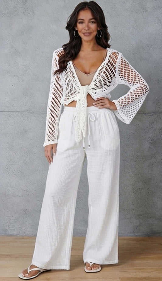 woman wearing a milio milano white gauze pant with beige and white crochet top