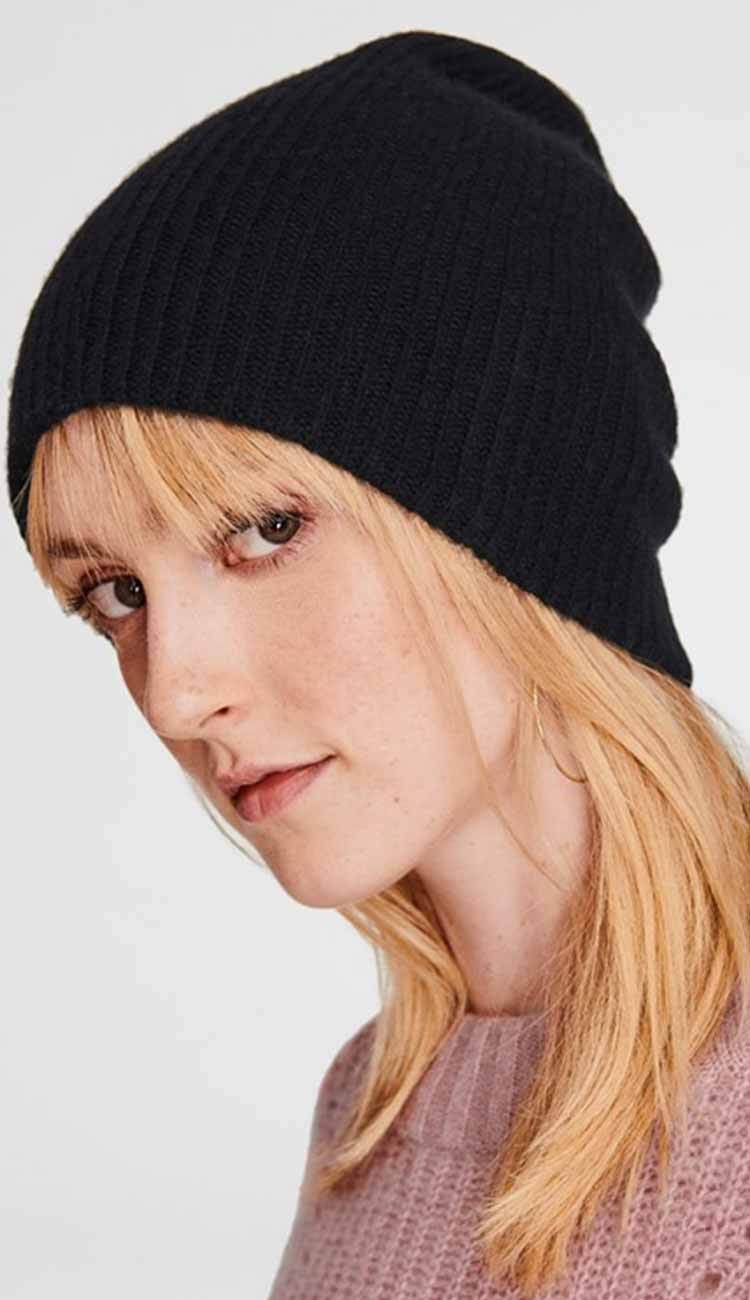 woman wearing a cashmere beanie in black by White and Warren on a white background
