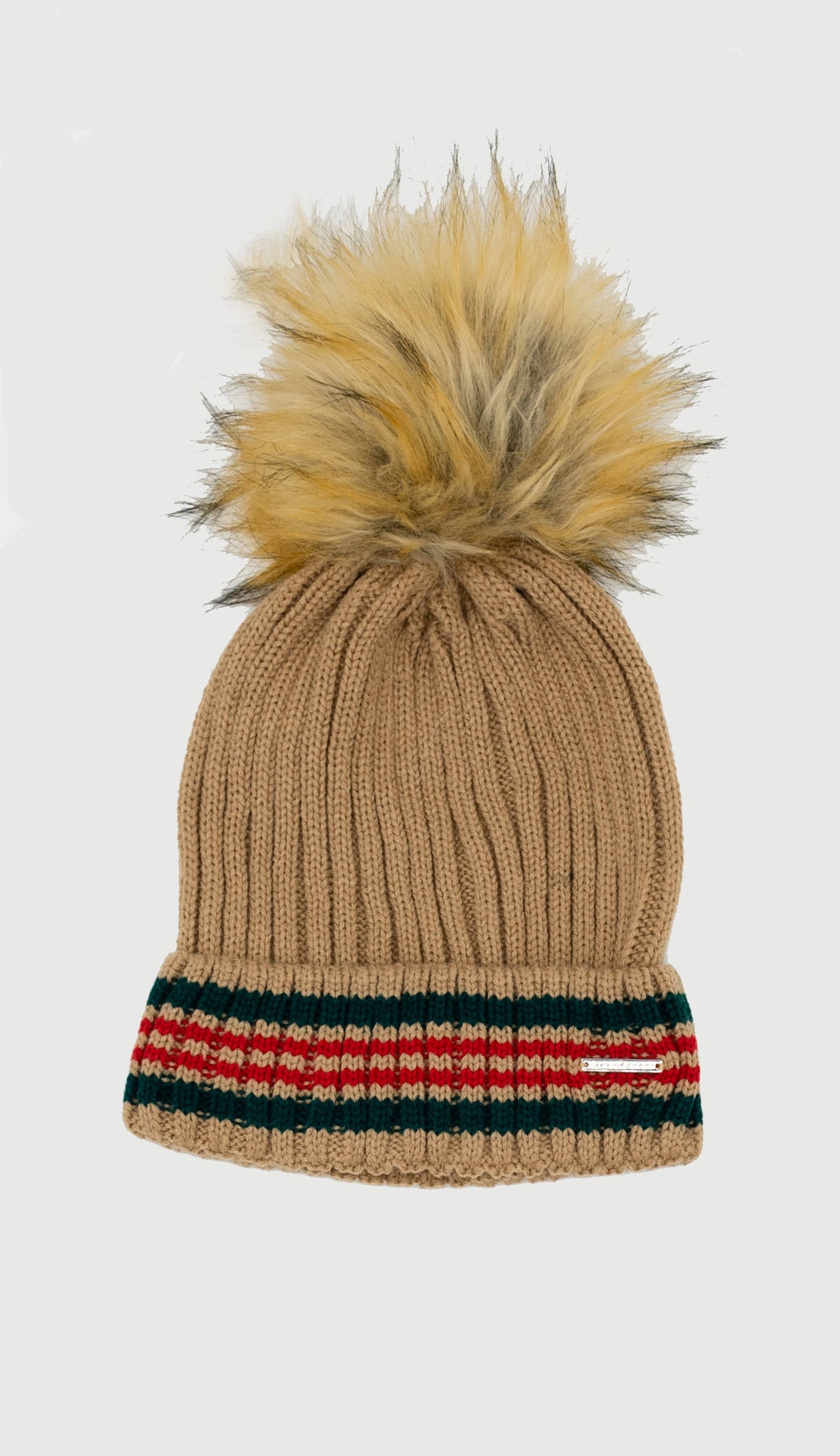 A beanie hat in camel color with a green and red stripe and a fur pom pom on top.