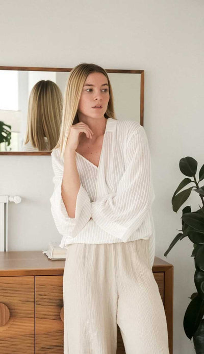 The Sade top’s surplice silhouette adds a romantic cross-front drape to a tunic body. An elongating vertical stripe cascades down its length. Flowing material feels irresistibly breezy with wide sleeves and a low back hem. It’s perfect for strolls in the sand or layering over a transitional look. Paula & Chlo